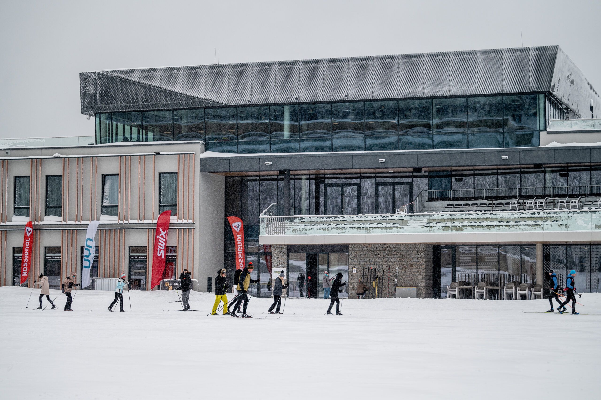 Narciarze biegowi przed budynkiem Dolnośląskiego Centrum Sportu Polana Jakuszycka
