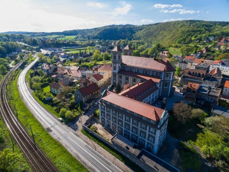 Widok z lotu ptaka na wzgórza, lasy i domy.