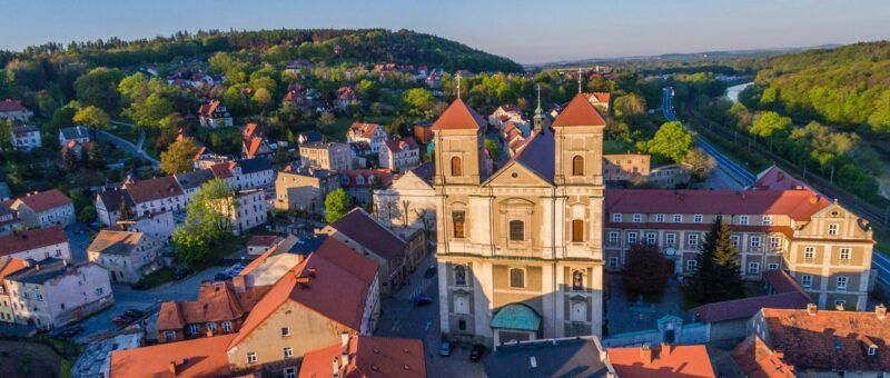 Widok na rynek, budynki, w tle zieleń.