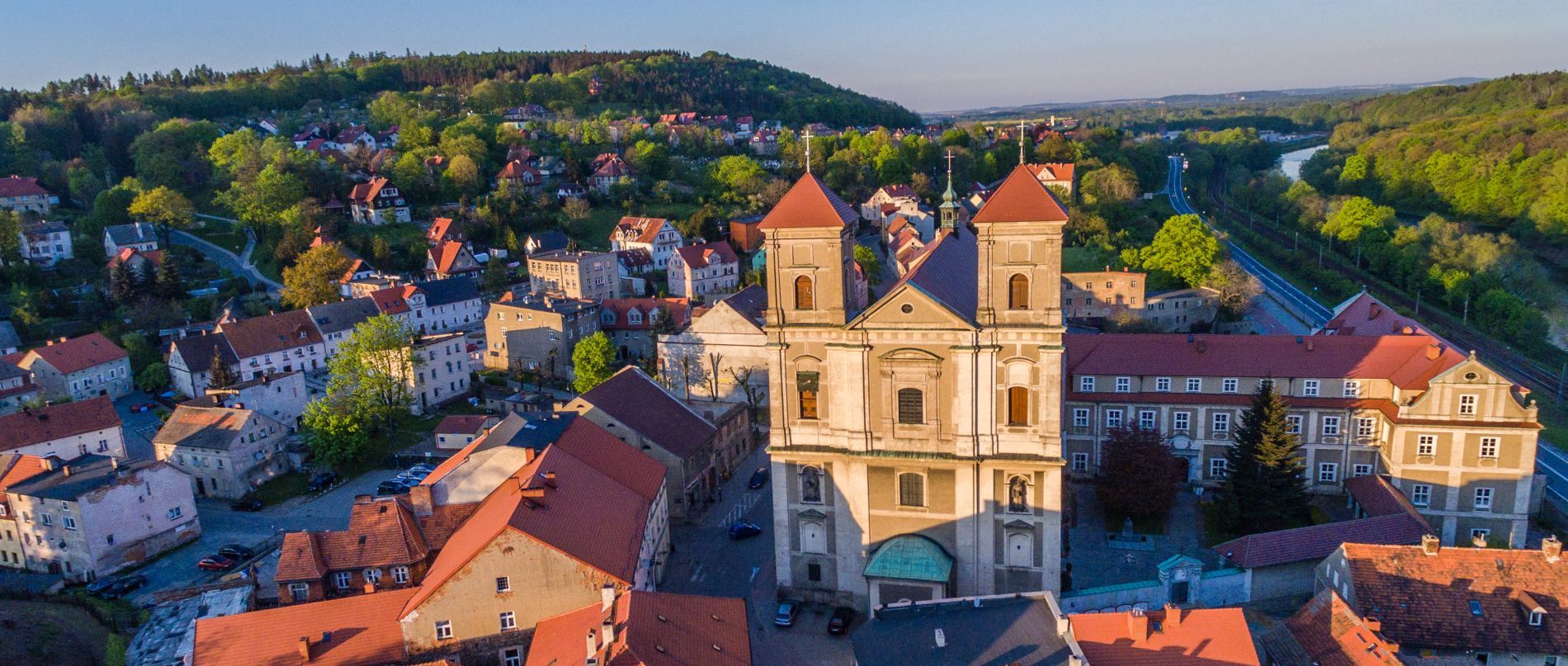 Widok na rynek, budynki, w tle zieleń.