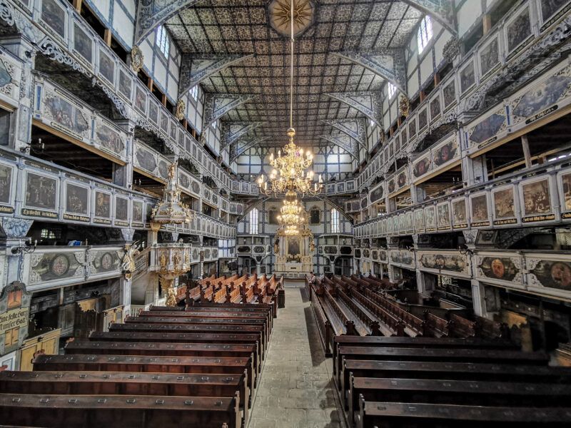 Drewniane wnętrze Kościoła Pokoju, prezentujące barokowy ołtarz główny, pięknie zdobioną ambonę oraz 4 kondygnacje empor zdobionych malowidłami przedstawiającymi sceny biblijne oraz herby lokalnych możnowładców.