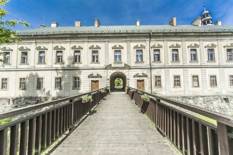 Most prowadzący do zamku, jasna elewacja z pięknymi zdobieniami.
