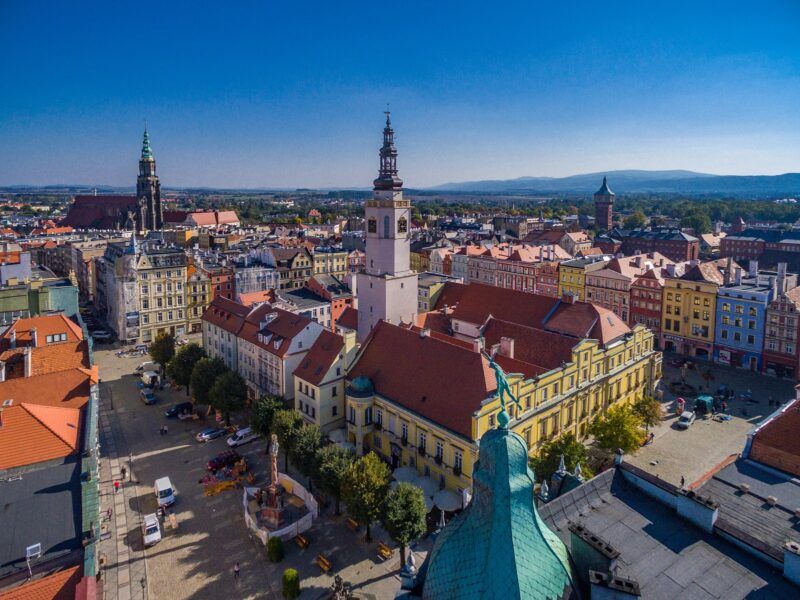 Panorama miasta z lotu ptaka. Wśród budynków wyróżniają się wieże katedry oraz wieża ratuszowa na rynku w Świdnicy.