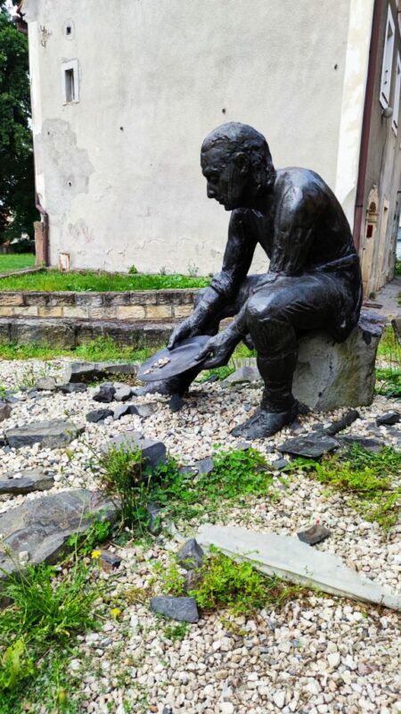 Posąg człowieka siedzącego na kamieniu.