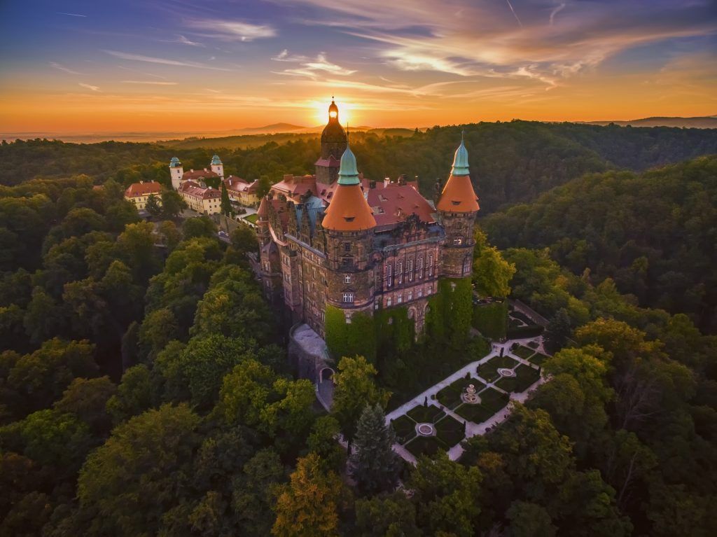 Majestatyczny Zamek usytuowany na wzgórzu Otoczony bujną przyrodą przy zachodzie słońca