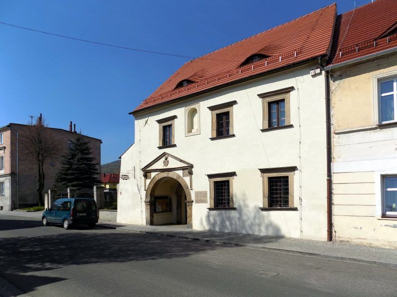 widok na biały dwupiętrowy budynek z czerwonym dachem, stanowiący muzeum