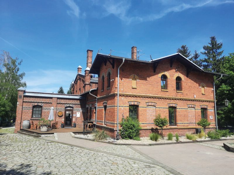 Widok na zabytkowy, niewielki, nieotynkowany budynek gazowni