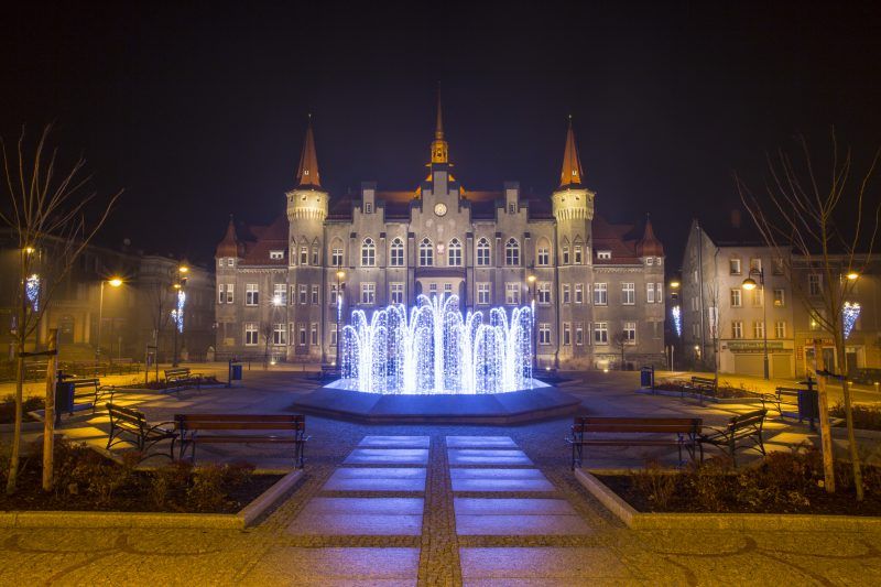 Nocny widok na urząd miasta w Wałbrzychu z podświetloną fontanną na pierwszym planie