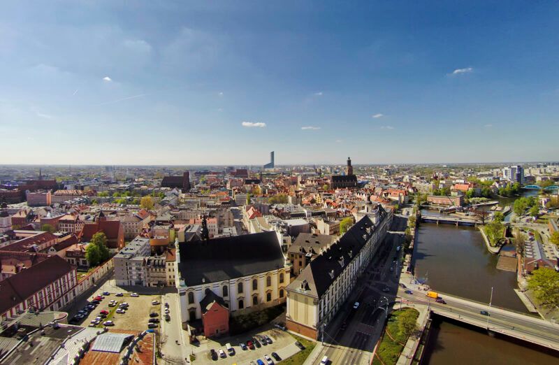 Widok na centrum dużego miasta z lotu ptaka na tle błękitnego nieba.