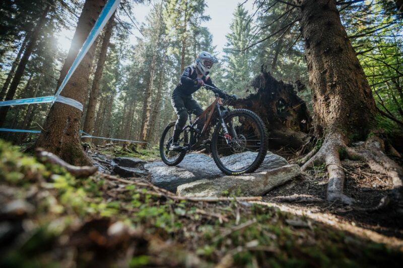 Zdjęcie rowerzysty na trasie górskiego wyścigu rowerowego jadący przez las