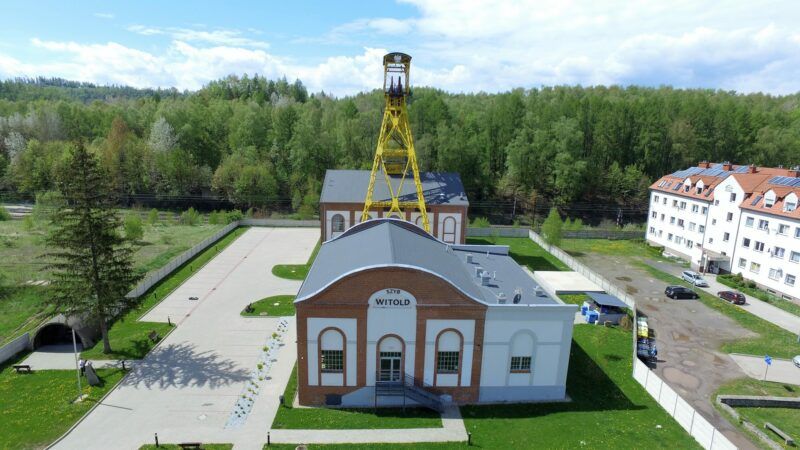 Widok z lotu ptaka na zabytkowy szyb górniczy z górami w tle