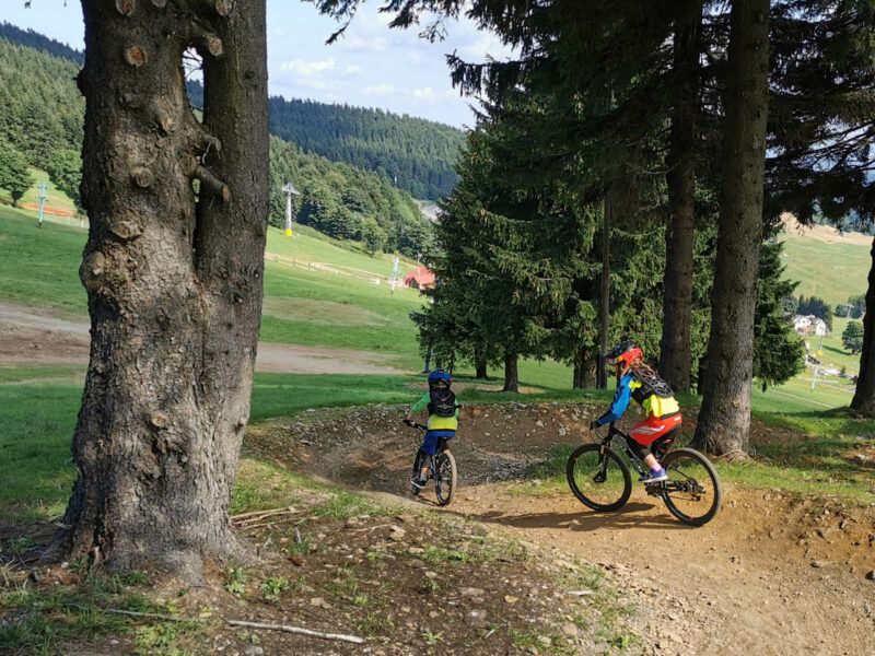 Dwójka rowerzystów zjeżdża po trasie z bandami