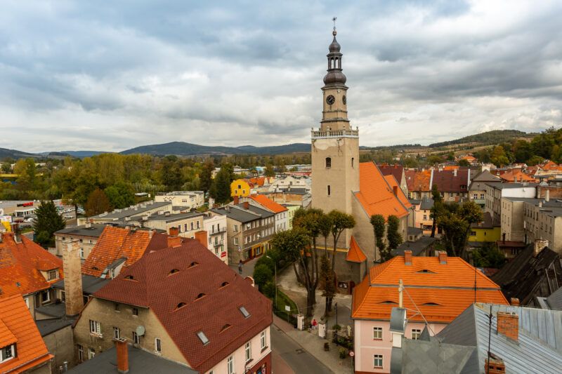 Widok z loty ptaka na zabudowania miasta Kamienna Góra na tle zachmurzonego nieba