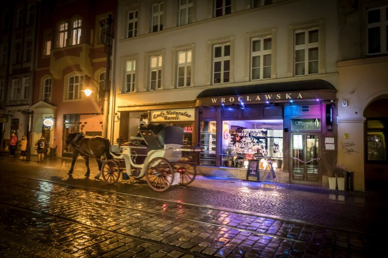 Nocny widok z ulicy na wejście do eleganckiej restauracji