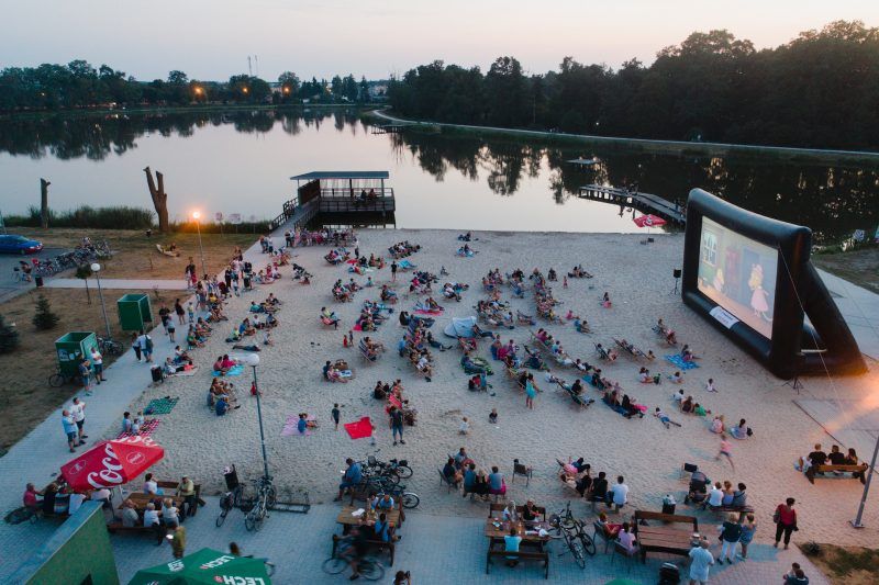 widok z góry na plaże przy stawie, na której jest organizowane kino plenerowe