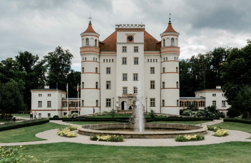 Pałac w stylu neogotyckim posadowiony na wysokim cokole, przechodzącym w taras po stronie południowej. 3-kondygnacyjny z mezzaninem na planie zbliżonym do kwadratu z okrągłymi alkierzowymi wieżami, nakryty stromym dachem namiotowym
