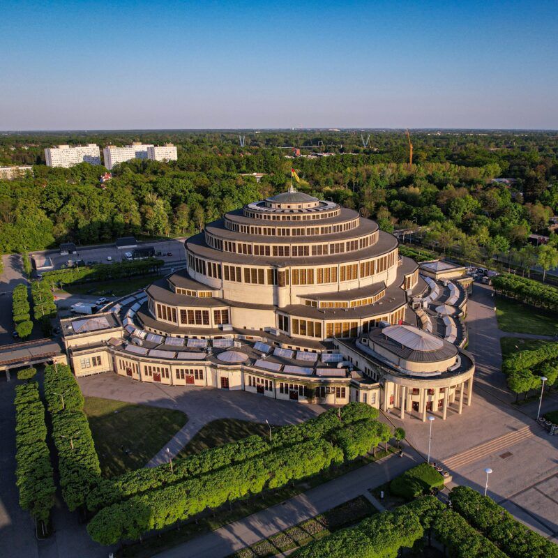 Widok z lotu ptaka na okrągły budynek Hali Stulecia z charakterystyczną kopułą.