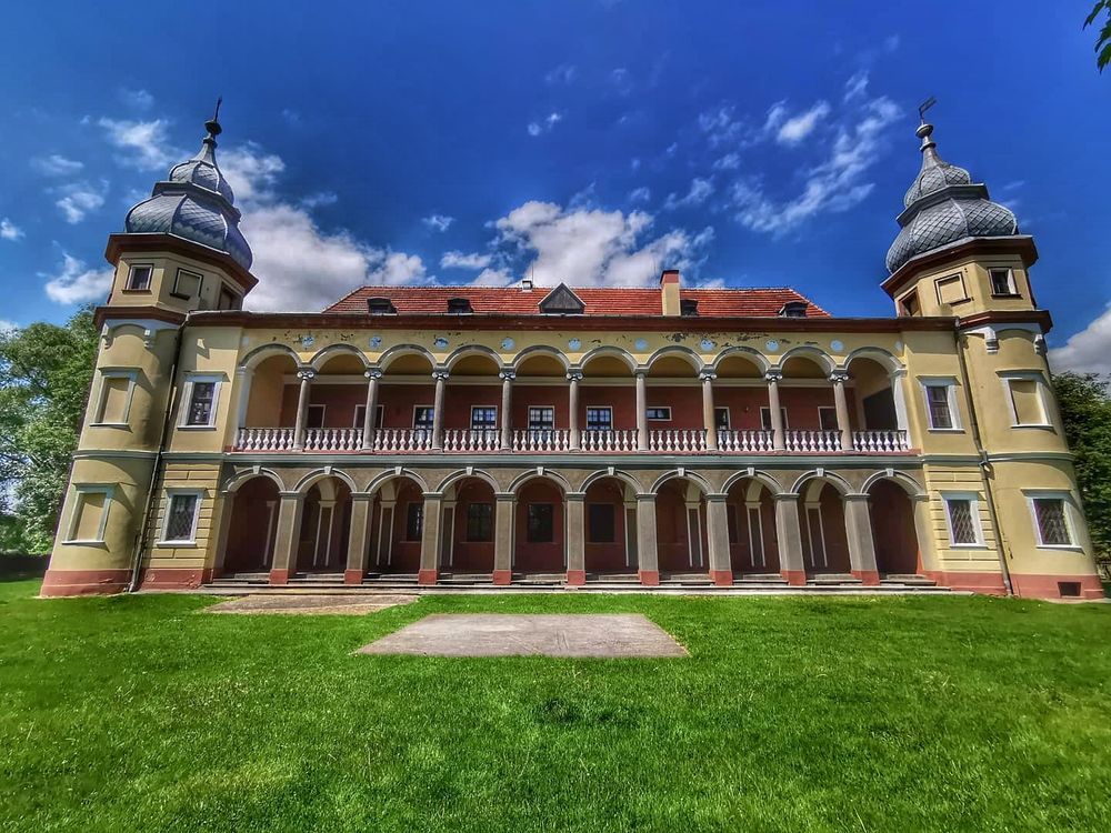 Zdjęcie wykonane na wprost na elewację boczną z dwupoziomowymi arkadami w Pałacu Krobielowice