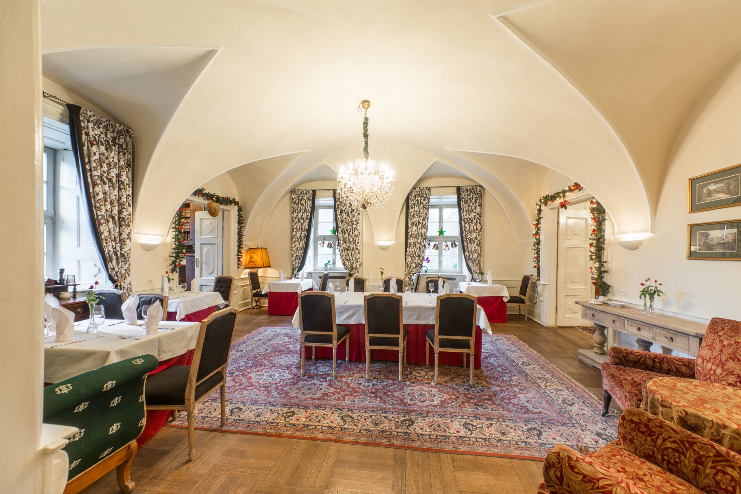 Wnętrze restauracji w stylu historyzującym, Na oknach duże, kotarowe zasłony. Stoły zastawione, przyszykowane na uroczystość.