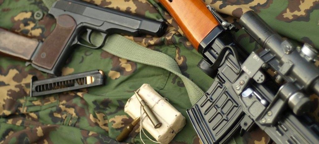 Zdjęcie karabinu i pistoletu na zielonym tle