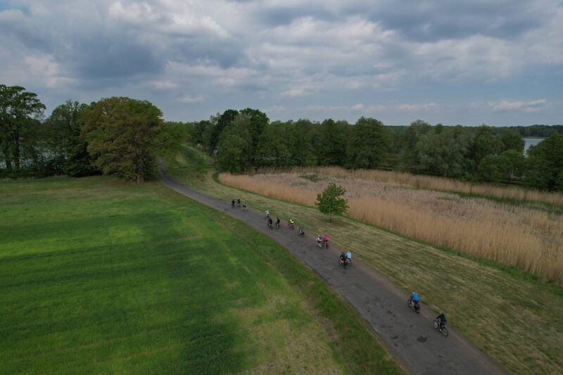 Droga między polami, na drodze rowerzyści.