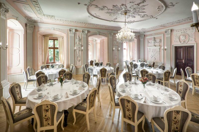 Sala w restauracji zamkowej z pięknie zastawionymi stołami