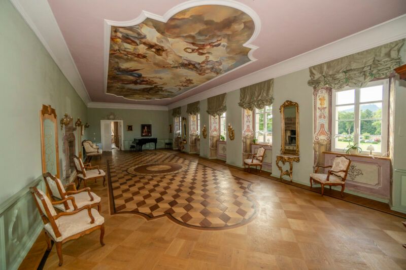 Stylowe, historyczne wnętrze komnat pałacowych, w których głównym dominantem są bogato zdobione wnęki okienne, sufit oraz drewniany parkiet. 