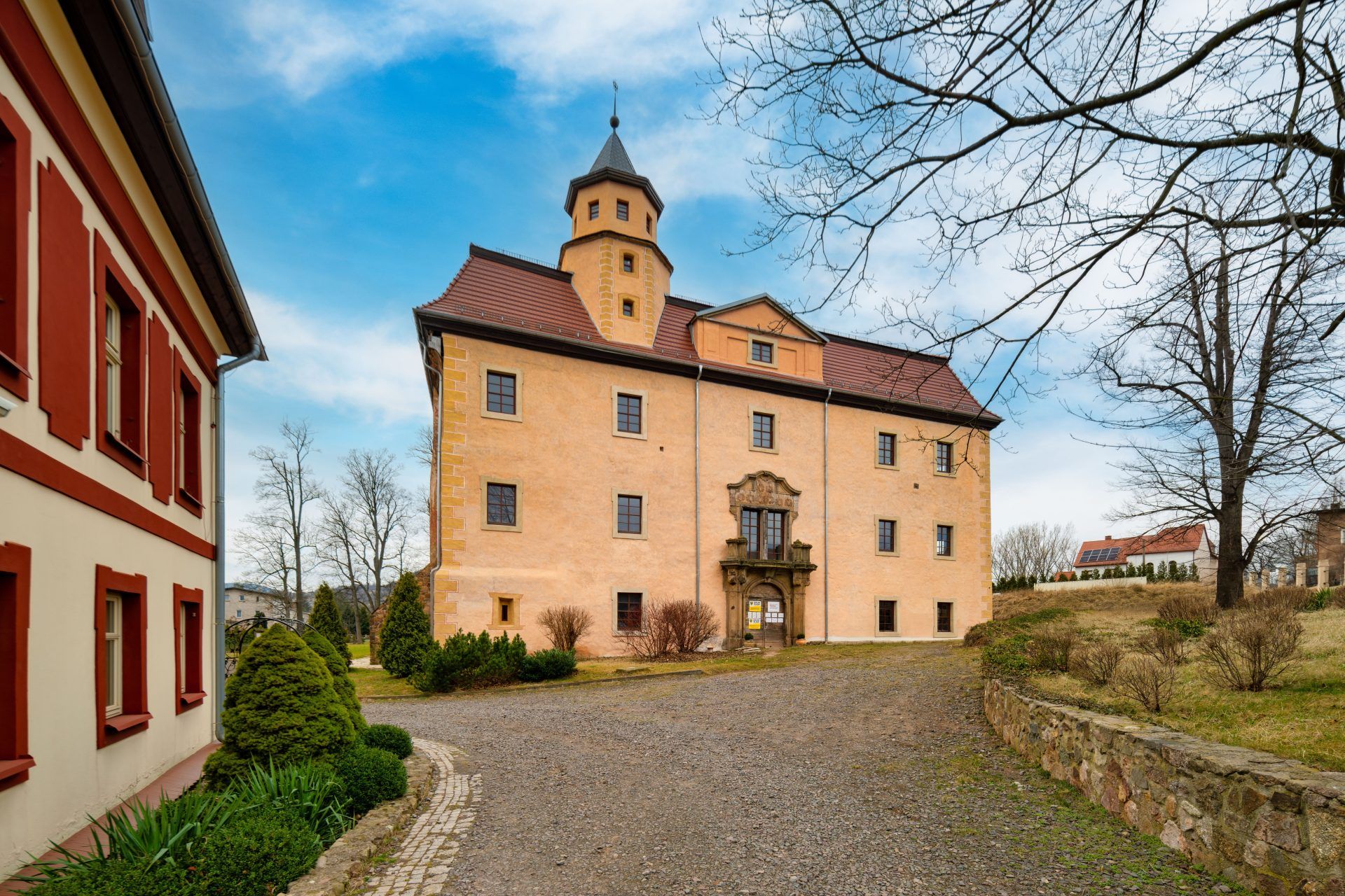 Na zdjęciu widać elegancki Pałac Struga – jasny, kilkupiętrowy budynek z ozdobnymi oknami i wieżyczką, otoczony zielenią i starymi drzewami, emanujący spokojem i historycznym urokiem.
