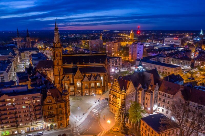 Panorama Legnicy nocą- podświetlony ratusz oraz budynek katedry