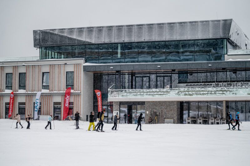 Narciarze biegowi przed budynkiem Dolnośląskiego Centrum Sportu Polana Jakuszycka