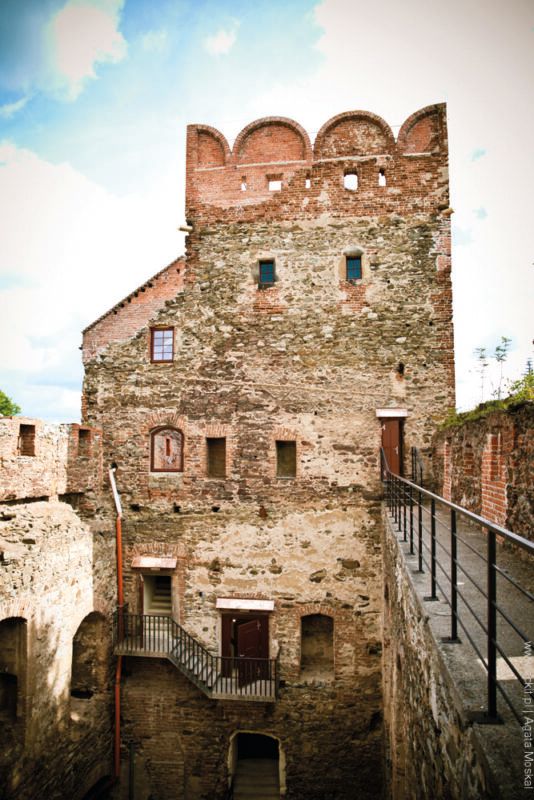 Widok od wewnętrznej strony ruin zamku na nieotynkowaną fasadę szesnastowiecznej wieży zamkowej.