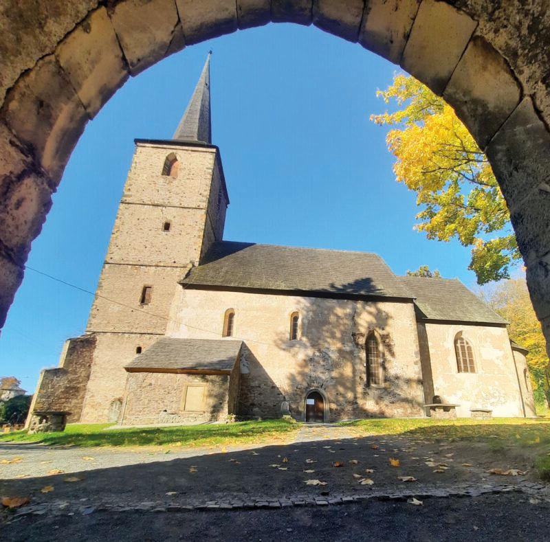 Widok na skąpany w słońcu romański kościół w Świerzawie od strony bocznej z dobrze widoczną wieżą na planie kwadratu