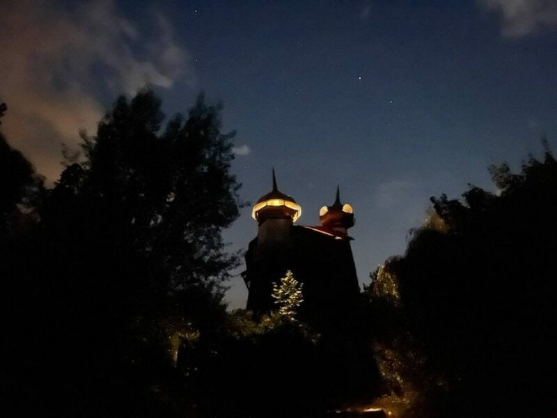 Wieża wśród drzew, nocą.