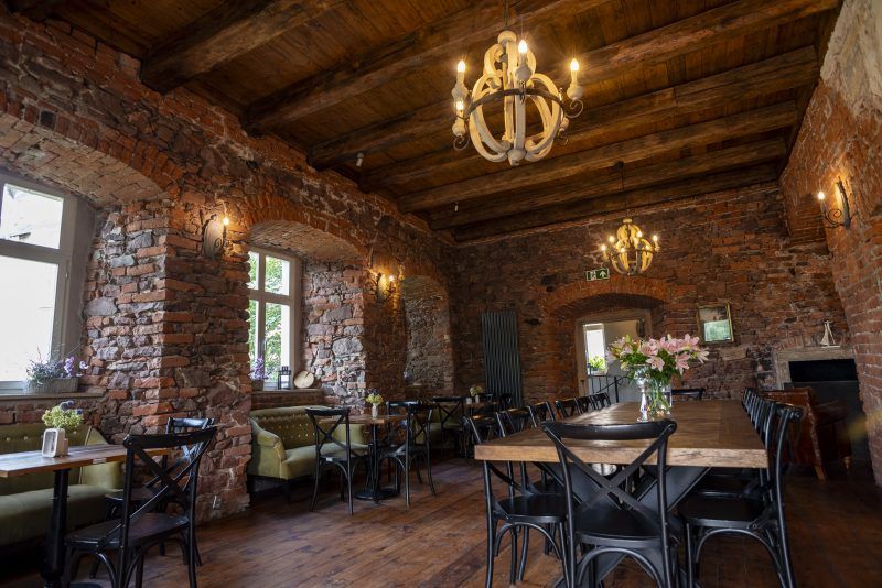 Wnętrza Zamku Sarny i restauracji z licznymi zabytkowymi elementami wyposażenia