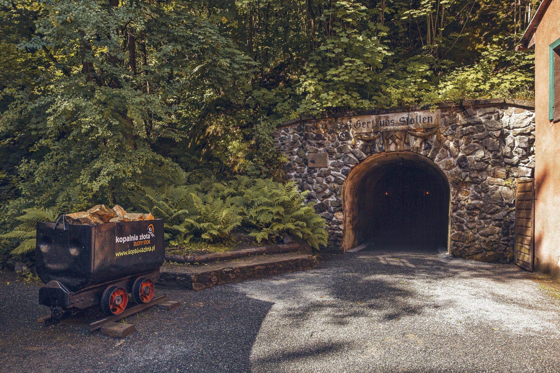 Wejście do sztolni z wagonikiem wypełnionym złotem widocznym na powierzchni