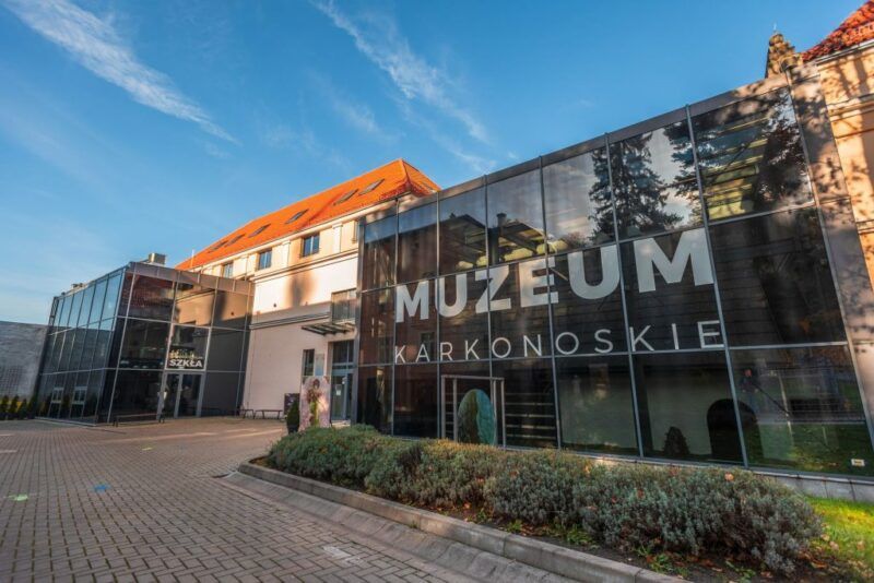 Budynek muzeum- budynek 2-pietrowy ze spadzistym dachem oraz szklaną nowoczesną dobudówką