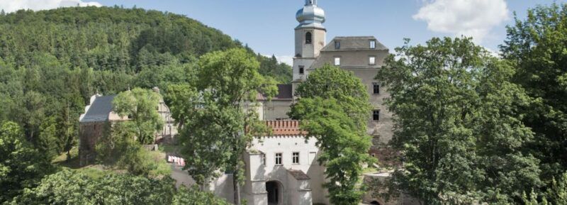 Widok na Zamek Sarny z wieżą ze wzgórzem w tle