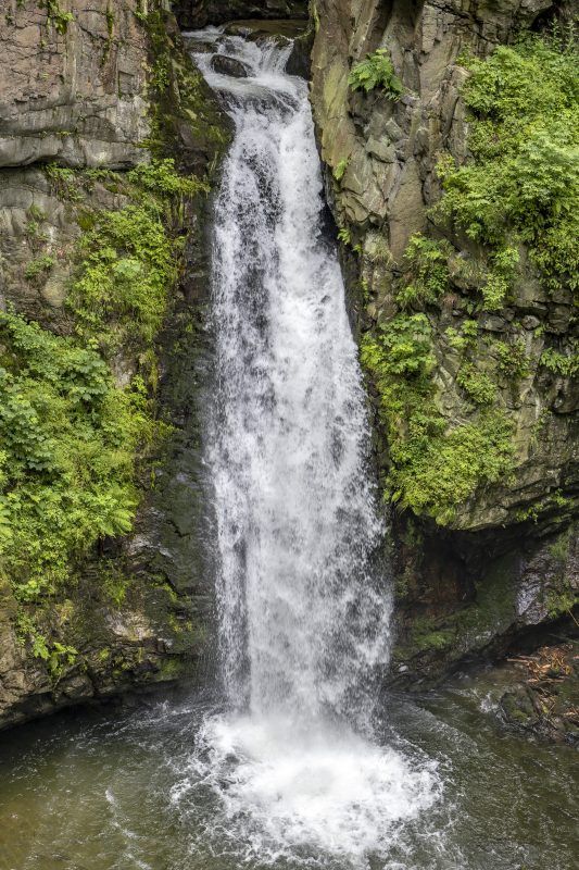 Zdjęcie wodospadu znajdującego się w górzystym terenie