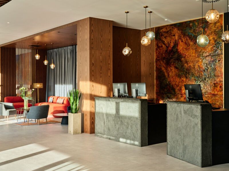 Recepcja hotelowa. Dekorację stanowią elementy drewniane połączone z kamiennymi.