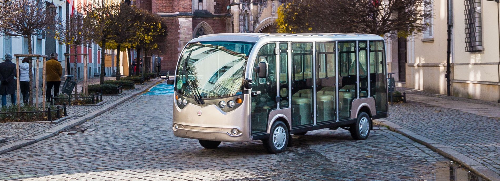 pojazd elektryczny (melex) stojący na ulicy z kostki na tle Sakralnego obiektu (Katedry) na Ostrowie Tumskim 