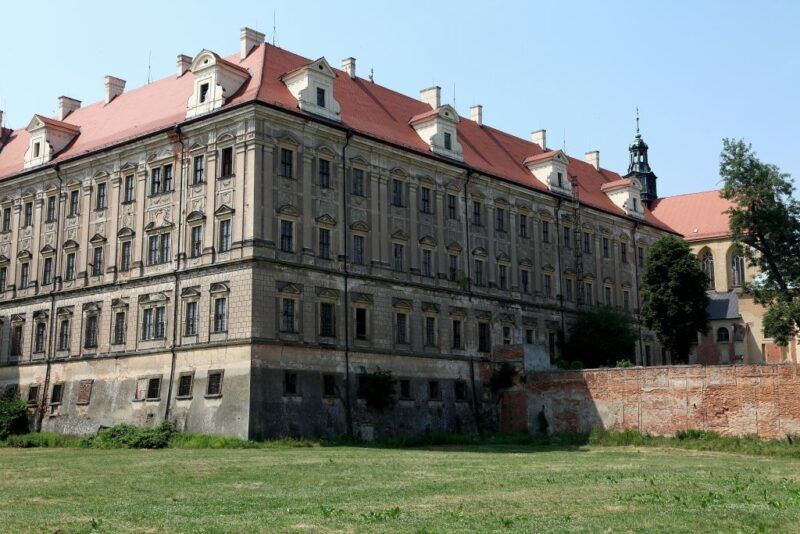 Zabytkowa barokowa budowla z wielkimi oknami z dachem w kolorze ceglanym
