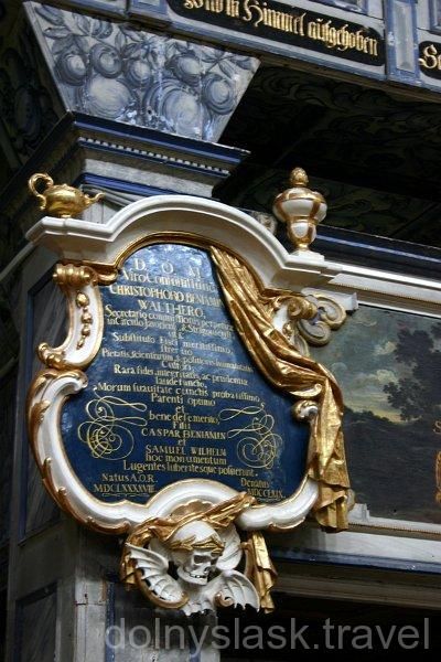 Epitafium  na czarnym tle w kształcie herbu otoczone złotą ramą