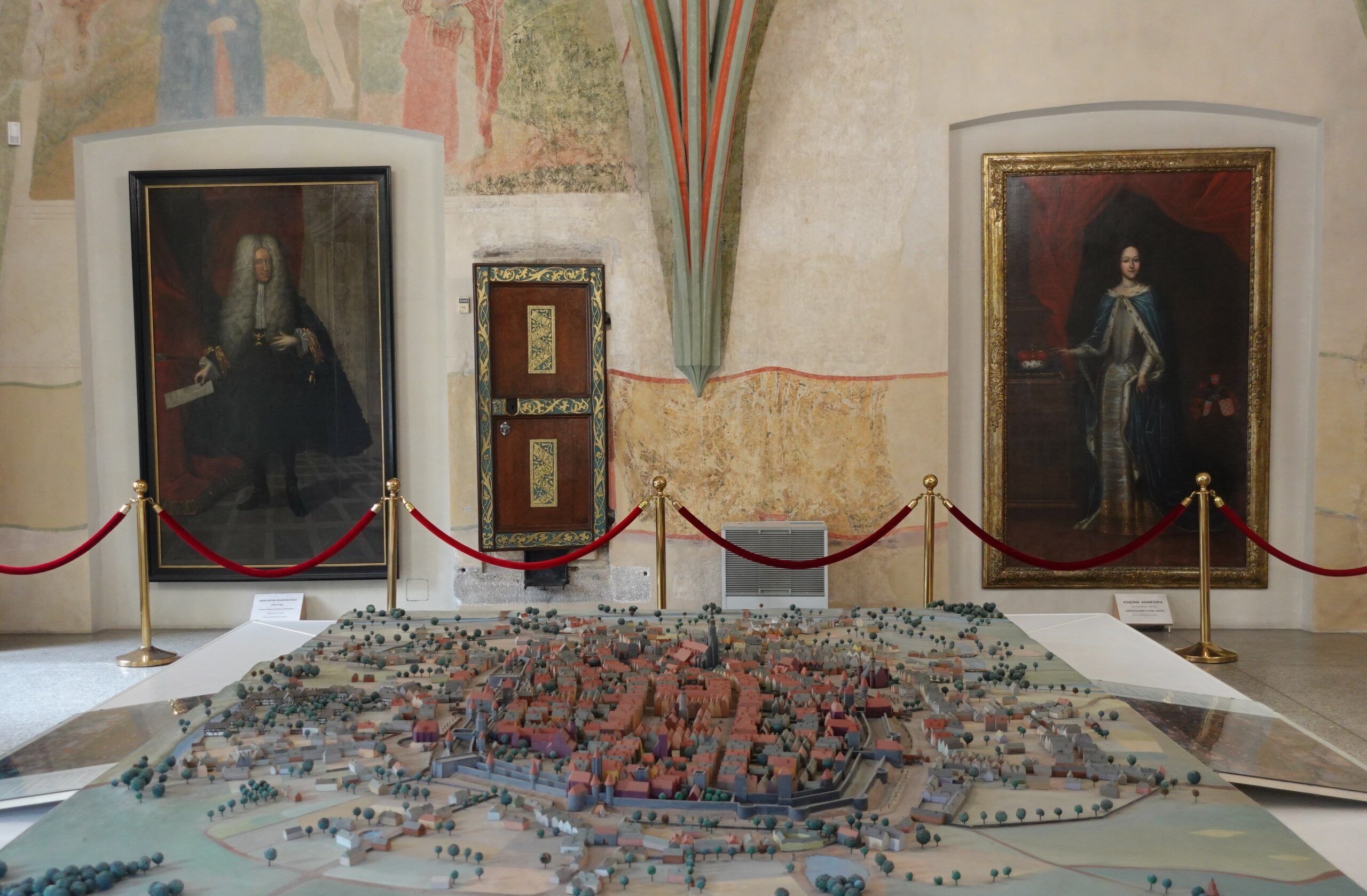 stara makieta miniaturowa ukazująca dawne miasto. w tle widać obrazy