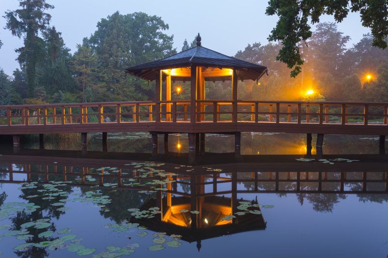 Drewniany pawilon w połowie długości drewnianego poomostu znajdującego się w ogrodzie japońskim we Wrocławiu