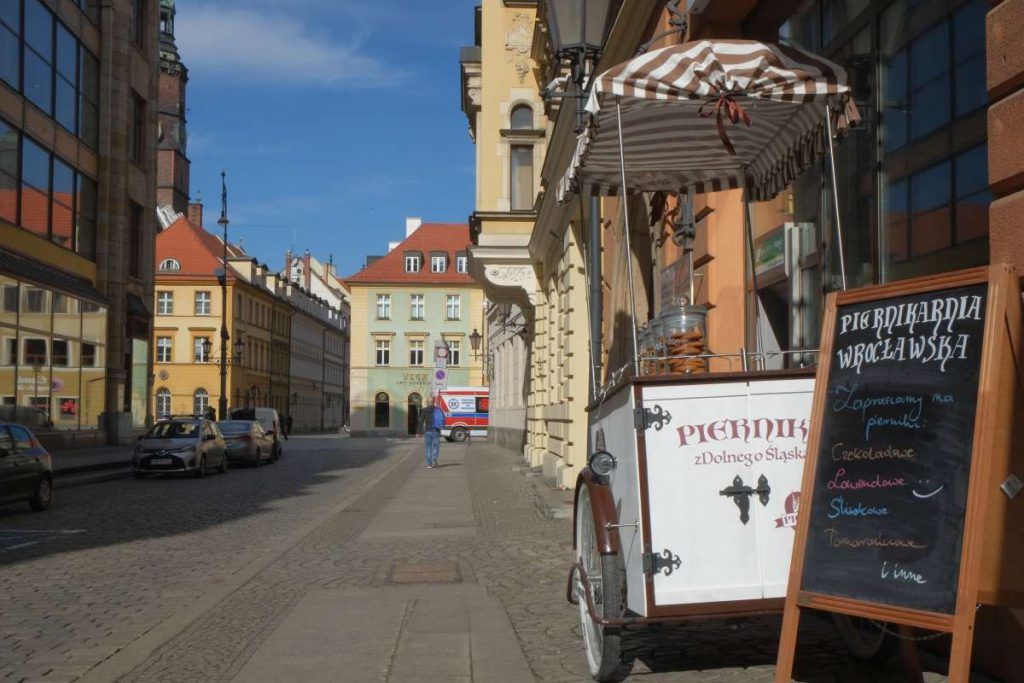Widok na ulicę, po prawej stronie wóz z piernikami.