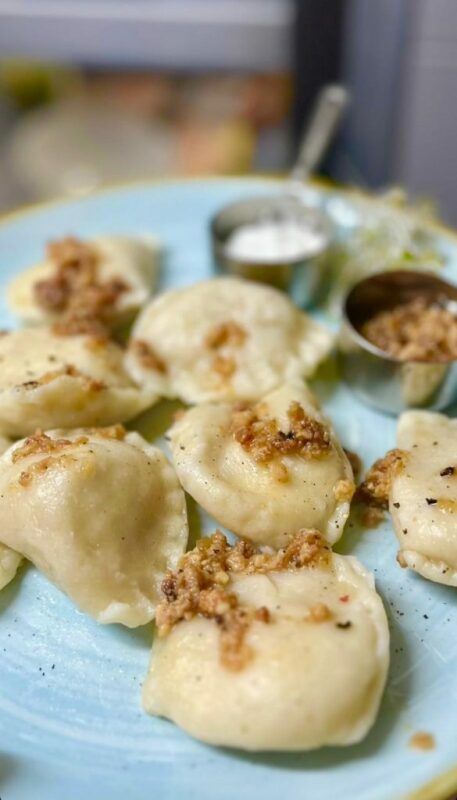 Pierogi podane na niebieskim talerzu.