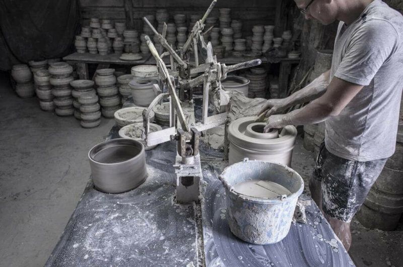Rzemieślnik wyrabiający naczynia ceramiczne w różnych pojemnikach 