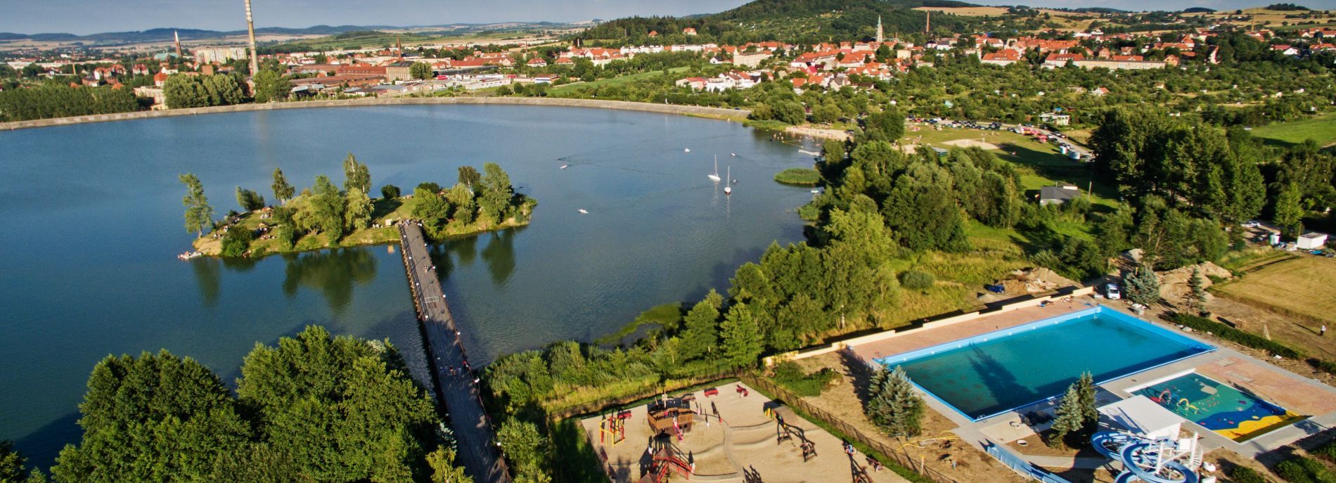 Widok z lotu ptaka na Jezioro Bielawskie, otoczone domkami oraz zielenią.