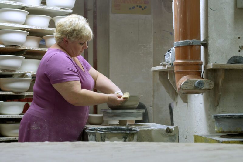 Kobieta w różowym stroju podczas pracy w fabryce porcelany
