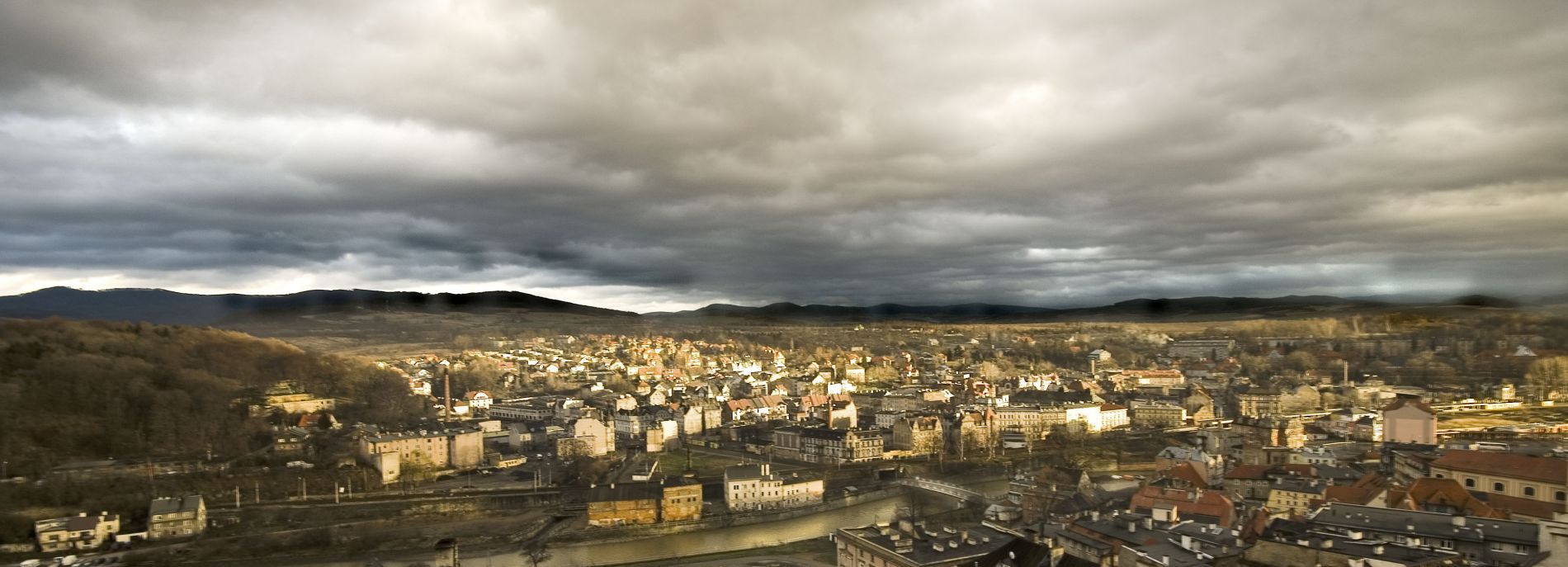 Panorama Kłodzka w oddali zabudowania przy pochmurnym burzowym dniu